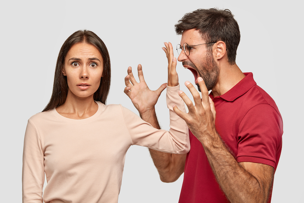 Shut up! Puzzled beautiful woman keeps palm near husbands mouth, asks him stop shouting at her. Jealous boyfriend screams with anger at girlfriend, suspects her in betrayal, sort out relationships